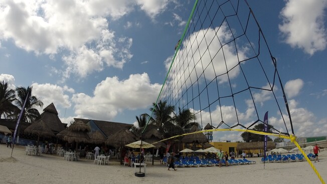 Corona Beach, featuring a volleyball net in the foreground, and a restaurant, beach umbrellas and many lounge chairs in the background Corona Beach, featuring a volleyball net in the foreground, and a restaurant, beach umbrellas and many lounge chairs in the background