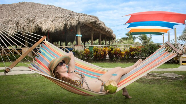 A woman lounging in a hammock at a tropical beach