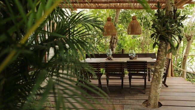 A shaded outdoor dining area with a table for 6