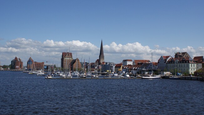 A townscape with a steeple and historical architecture near a marina