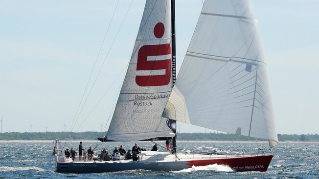 A racing yacht filled with passengers sailing the open waters