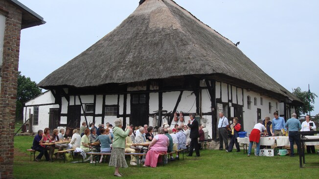Guests dining at picnic tables near stables built in the Tudor style