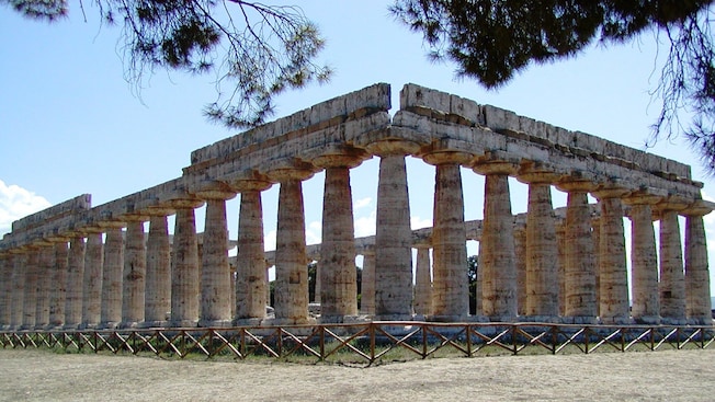 The ruins of an ancient building featuring stone columns The ruins of an ancient building featuring stone columns
