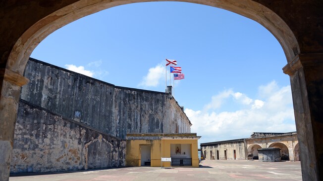 American and Puerto Rican flags flying above the historic stone fort of San Cristobal