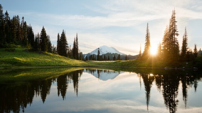 Un lago tranquilo rodeado de bosques y montañas Un lago tranquilo rodeado de bosques y montañas