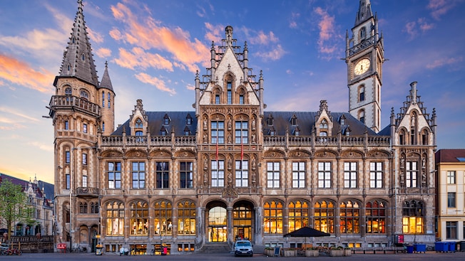 A watch tower next to a grand building built in a neo Gothic style A watch tower next to a grand building built in a neo Gothic style