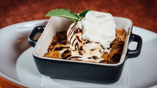 Postre de masa de galleta al horno cubierto con crema y una ramita de menta