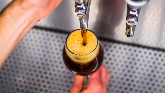 Cerveza saliendo de un pico hacia una copa