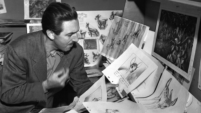 Walt Disney looks at sketches