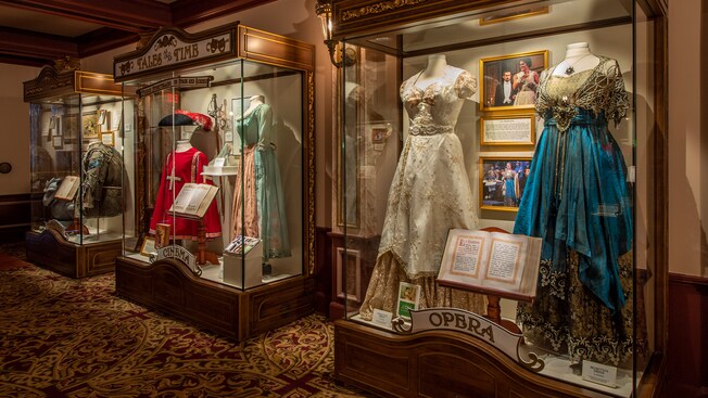 Tres vitrinas iluminadas que contienen trajes, objetos de utilería y otros recuerdos de una variedad de presentaciones de teatro, cine y ópera.