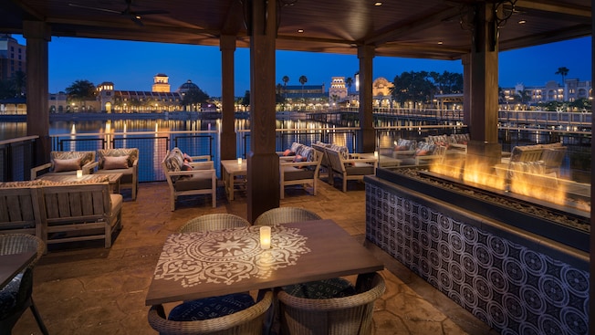 Mesas y sillas en la habitación a la luz de las velas con vista a los puentes afuera sobre la laguna
