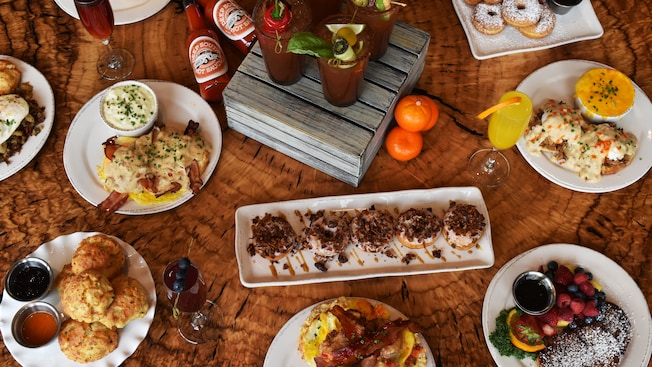 Assorted breakfast cocktails and dishes including bacon and pecan doughnuts, biscuits and jam and eggs