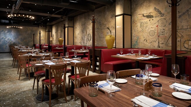 Un restaurante con mesas abiertas y cerradas preparadas para la cena