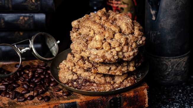 A stock of Coffee Cake Cookies sitting on an old book surrounded by coffee beans