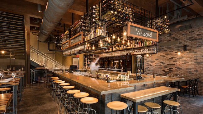 A wine bar with an open ceiling and a large supply of products stored overhead