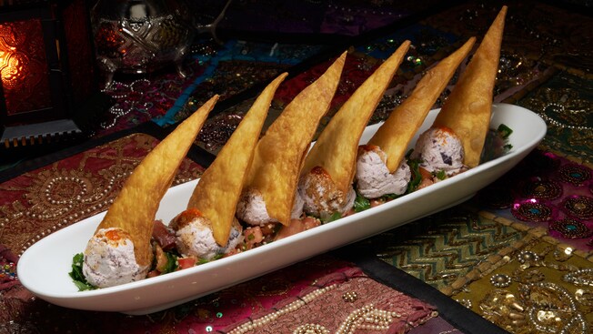 A long, narrow dish with 6 pointed, upright slices of bread all supported by scoops of goat cheese