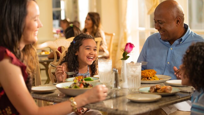 A family shares a laugh, dining together in Grand Floridian Café at Walt Disney World Resort