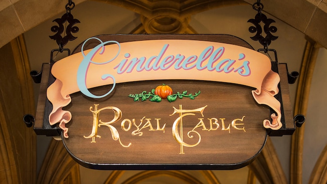 The Cinderellas Royal Table restaurant sign hangs above the location entrance