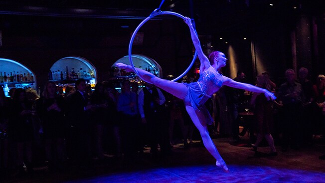 A performer hangs from a hula hoop