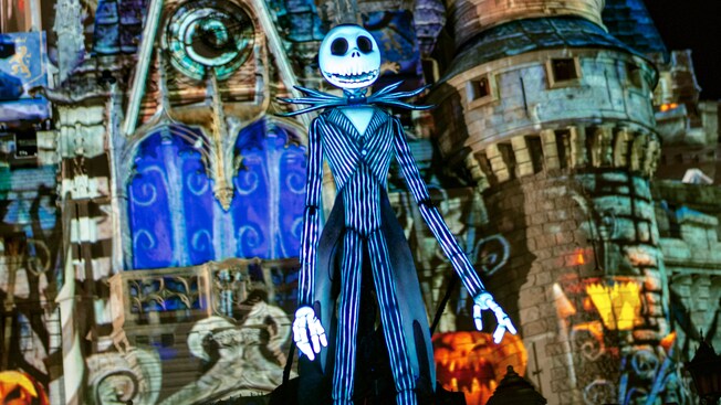Jack Skellington stands in front of Cinderella Castle bearing Halloween themed projection effects