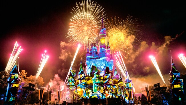 Stunning projections cover Cinderella Castle as fireworks light up the night sky