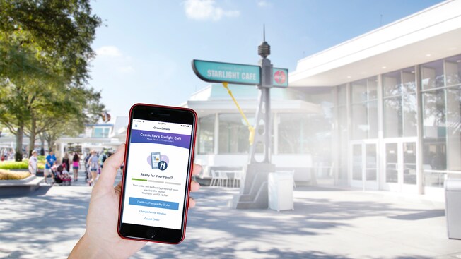 A hand gripping a mobile phone outside of a dining location