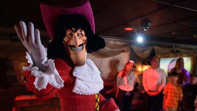 Captain Hook strikes a fiendish pose as families look on