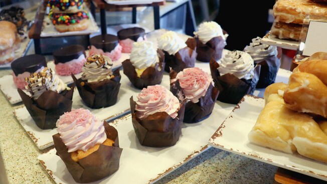 Rows of cupcakes with donuts and pastries on trays