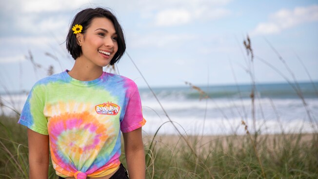 A smiling woman wears a shirt with words that read Ron Jon Surf Shop