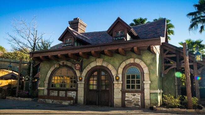 A quaint shop that appears like it is from rural France, with a sign hanging near the door that reads Bonjour Village Gifts