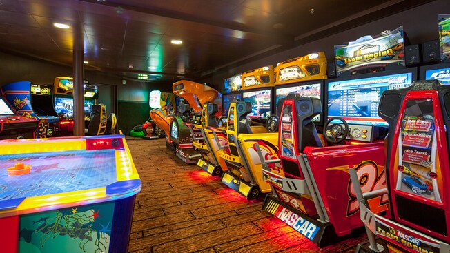 Una sala de juegos con una gran variedad de videojuegos interactivos de alta tecnología y el clásico hockey de mesa