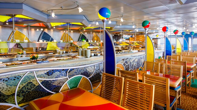 A wooden sign says, Beach Blanket Buffet, and has a 3 D wooden surf board, kite and blanket