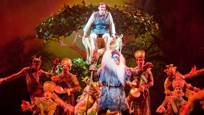 A father watches from a tree as Rafiki from The Lion King shares wisdom in a song accompanied by drums A father watches from a tree as Rafiki from The Lion King shares wisdom in a song accompanied by drums