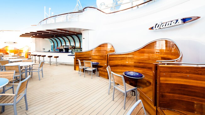 An outdoor lounge called Waves has tables and chairs as well as booth seating