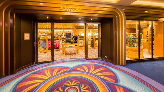 Alfombra colorida y una puerta dorada y brillante afuera de White Caps, una tienda