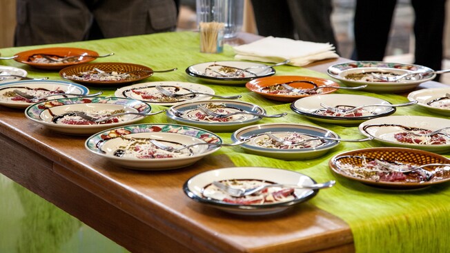Plated tasting samples on a table with forks, napkins and toothpicks