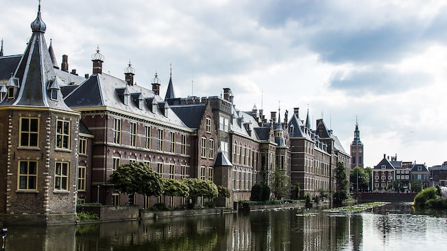 The Binnenhof sits on the edge of a lake with a clock tower in the background