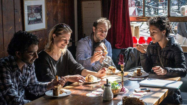 A group of people eat pie and ice cream at a table
