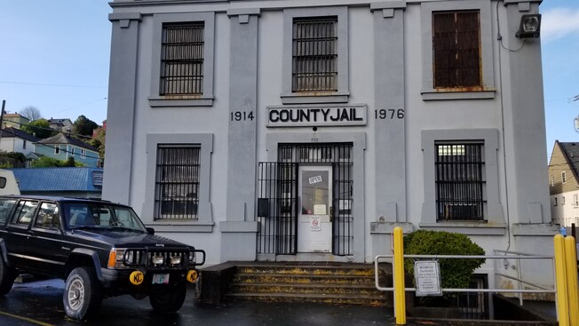 Un auto cerca de un edificio que dice 1914 County Jail 1976 (Cárcel del Condado)