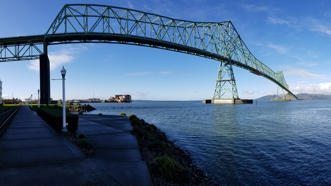 A bridge over a body of water near street lamps and a dock