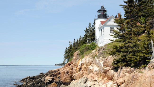 A lighthouse on a cliff overlooking the water A lighthouse on a cliff overlooking the water
