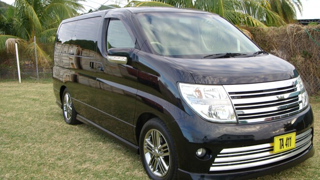 Uma minivan de passageiros parada em um campo de grama rasteira