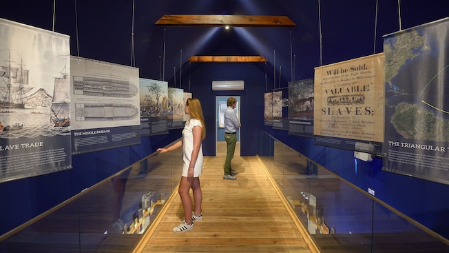 2 people in a museum look at information regarding the history of the Caribbean 2 people in a museum look at information regarding the history of the Caribbean