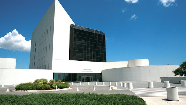 A modern building with tinted windows and a cement pathway A modern building with tinted windows and a cement pathway