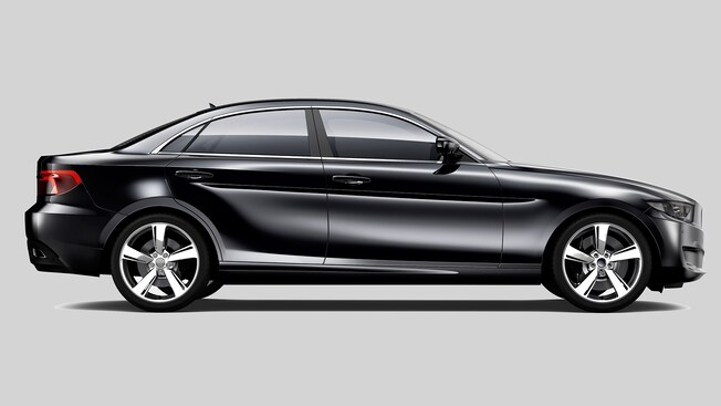 Side view of a gleaming black sedan with shiny chrome wheels
