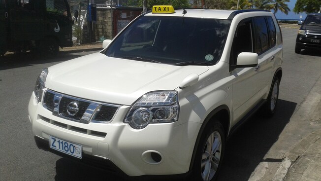 Un SUV de Nissan es un taxi en funcionamiento estacionado al lado del camino