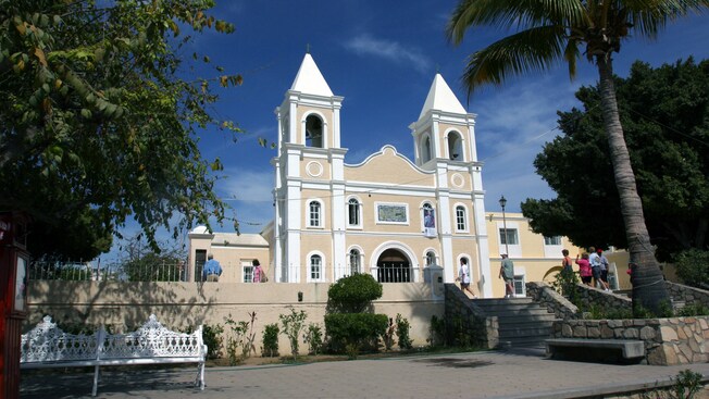 Uma igreja com duas torres com um grupo de turistas no pátio