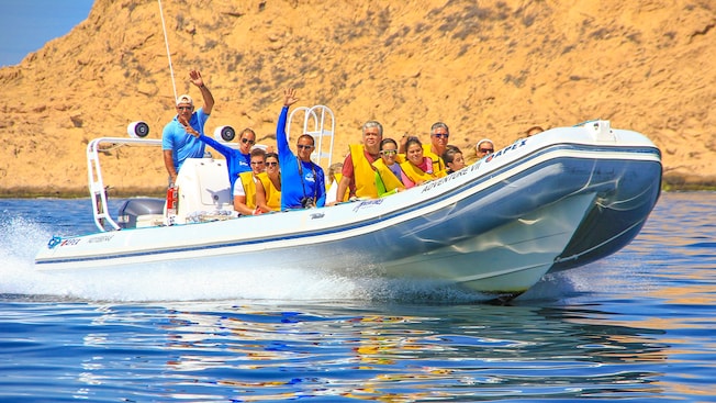 A rigid inflatable boat filled with passengers cruising the waters of Cabo San Lucas A rigid inflatable boat filled with passengers cruising the waters of Cabo San Lucas