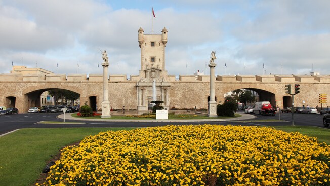 Puerta de Tierra featuring columns with statues, a fountain and more