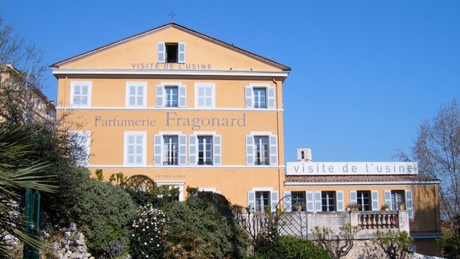 Large French lettering on the side of a 3-story building identifies it as the Perfumer’s Apprentice